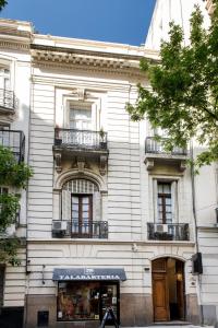 un edificio blanco con balcones y una tienda en Patios de Recoleta en Buenos Aires