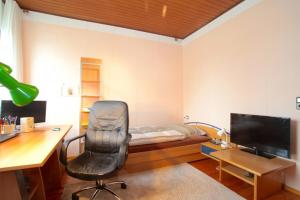 1 dormitorio con cama, escritorio y silla en Private Rooms, en Hannover