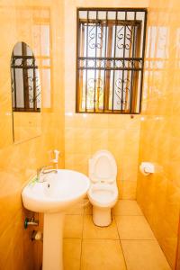 baño con lavabo y aseo y ventana en Jaden Hotel & Lounge - Arusha, en Arusha