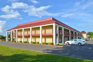 ein Hotel mit einem Auto auf einem Parkplatz in der Unterkunft Americas Best Value Inn Tupelo Barnes Crossing in Tupelo