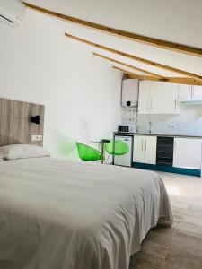 1 dormitorio con 1 cama blanca y 1 silla verde en Hotel Madrid Río, en Madrid