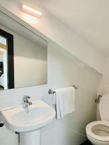 Baño blanco con lavabo y espejo en Hotel Madrid Río, en Madrid