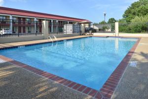 a large swimming pool in front of a building at Americas Best Value Inn Tupelo Barnes Crossing in Tupelo