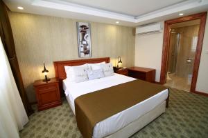 a hotel room with a large bed and a bathroom at Tuzla Garden Hotel & Spa in Tuzla