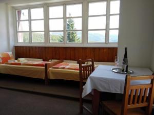 2 Betten in einem Zimmer mit einem Tisch und einem Fenster in der Unterkunft Horská chata Sedmidolí in Špindlerův Mlýn