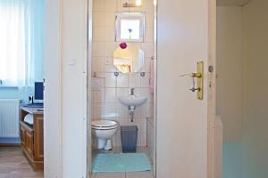 ein Badezimmer mit einem weißen WC und einem Waschbecken in der Unterkunft Private Apartment in Hannover