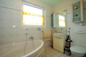 a bathroom with a tub and a toilet and a sink at Private Rooms in Hannover