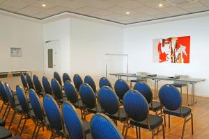 a conference room with blue chairs and a table at Hôtel Méditerranée in Calvi