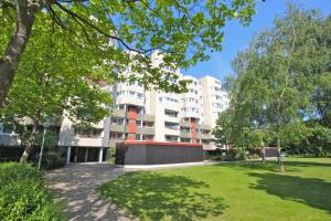 un gran edificio de apartamentos con un parque enfrente en Private Rooms Laatzen, en Hannover