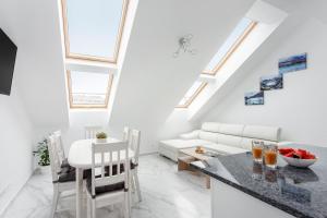 a kitchen and living room with a table and chairs at Luxurious Kaunas Basilica Apartment in Old Town by Urban Rent in Kaunas