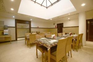 una sala da pranzo con tavoli, sedie e lucernario di Hotel Diamond Plaza a Chandīgarh