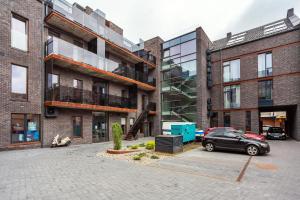 a car parked in a parking lot in front of buildings at Luxurious Kaunas Basilica Apartment in Old Town by Urban Rent in Kaunas