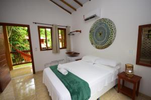 a bedroom with a white bed in a room at Pousada Quintessência - Tranquilidade, Natureza, Yoga in Arraial d'Ajuda +77 photos
