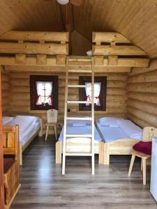 a bedroom with two bunk beds in a wooden cabin at Camp PACHO in Prievidza