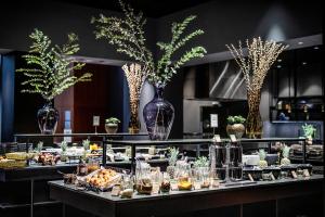 a buffet line with vases of food and desserts at Clarion Hotel Copenhagen Airport in Copenhagen