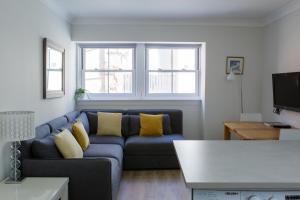 a living room with a blue couch and two windows at The Haven in Dunbar