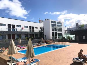 basen w hotelu z osobami siedzącymi na leżakach w obiekcie Mar de fuerteventura w Corralejo