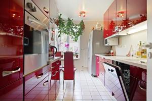 ハノーファーにあるPrivate Roomの白いフロアのキッチン(赤いキャビネット付)