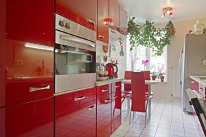 ハノーファーにあるPrivate Roomのキッチン(赤いキャビネット、テーブル、赤い椅子付)