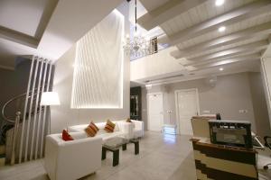 a living room with white furniture and a chandelier at Hotel Diamond Plaza in Chandīgarh