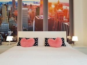 um quarto com uma cama com duas almofadas de coração em BSUITES TRIESTE em Pádua