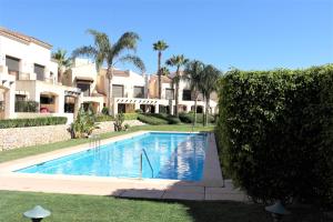 a swimming pool in a yard next to a building at Townhouse overlooking the pool in San Javier