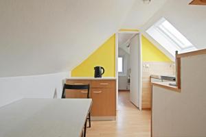 une cuisine avec une table et un mur jaune dans l'établissement Private Apartment, à Hanovre