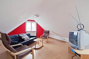 - un salon avec un canapé et une télévision dans l'établissement Private Apartment, à Hanovre
