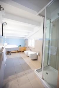 uma casa de banho com 2 lavatórios, uma banheira e um chuveiro em Selenite em Capo dʼOrlando
