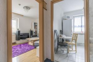 eine Küche und ein Wohnzimmer mit einem Tisch und einem Kühlschrank in der Unterkunft Private Apartment in Hannover