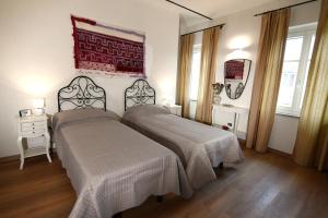 a bedroom with two beds and a painting on the wall at Casa delle Rocche in Monteu Roero