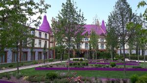 a large building with a flower garden in front of it at Gardaland Magic Hotel in Castelnuovo del Garda