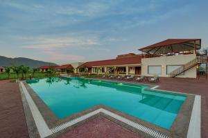 une grande piscine en face d'un bâtiment dans l'établissement The Fern Sattva Resort - Polo Forest, à Vijayanagar
