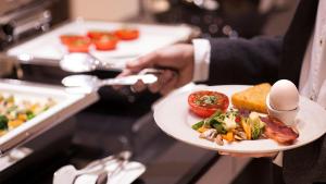 a person is holding a plate of food at Ramada Hotel & Suites by Wyndham Yerevan in Yerevan