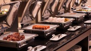 a buffet with several trays of food on a table at Ramada Hotel & Suites by Wyndham Yerevan in Yerevan