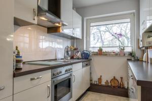 una cocina con electrodomésticos blancos y una ventana en Private Rooms, en Gestorf
