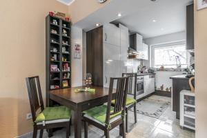 una cocina con mesa de madera y sillas. en Private Rooms, en Gestorf