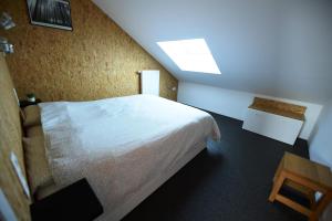 a bedroom with a white bed and a skylight at Le 42 in Durbuy