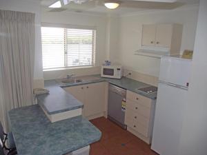 a kitchen with a white counter top and white cabinets at River Sands Apartments in Maroochydore