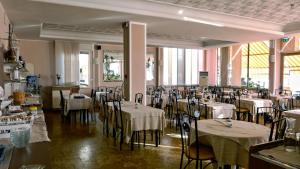 un restaurante con mesas y sillas con mantel blanco en Hotel Delfino, en Laigueglia