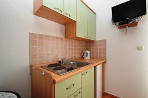 a small kitchen with a sink and a microwave at Apartments Dario in Rovanjska