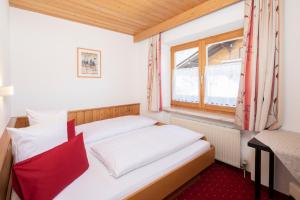 two beds in a small room with a window at Haus Konrad in Reith im Alpbachtal