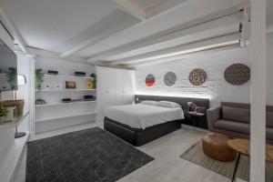 a bedroom with a bed and a couch and a chair at Malasaña Boutique in Madrid