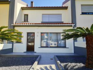 a white house with two palm trees in front of it at House Seven in Horta