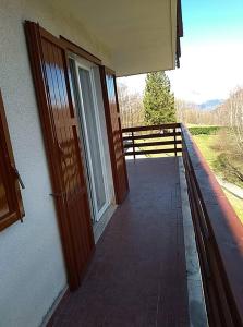 einen Balkon mit einer Tür und eine Veranda mit einem Zaun in der Unterkunft Oasi di Pace e Tranquillità in Zelbio