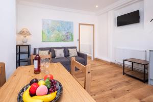 a living room with a table with a bowl of fruit at Birch – Three Tuns Apartments in Pettistree