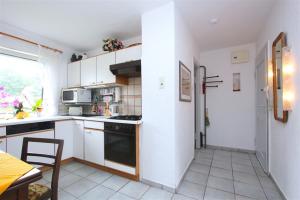 een keuken met witte kasten en een fornuis met oven bij Private Apartment in Hannover