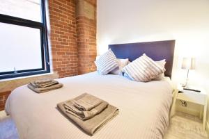 a bedroom with a large bed with towels on it at Aire Apartments New York Styled Luxury Apartments in Leeds