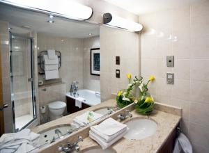 a bathroom with a sink and a large mirror at Apollo Hotel in Basingstoke