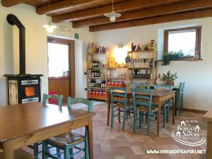ein Esszimmer mit Tischen, Stühlen und einem Herd in der Unterkunft Borgo dei Sapori in Cividale del Friuli